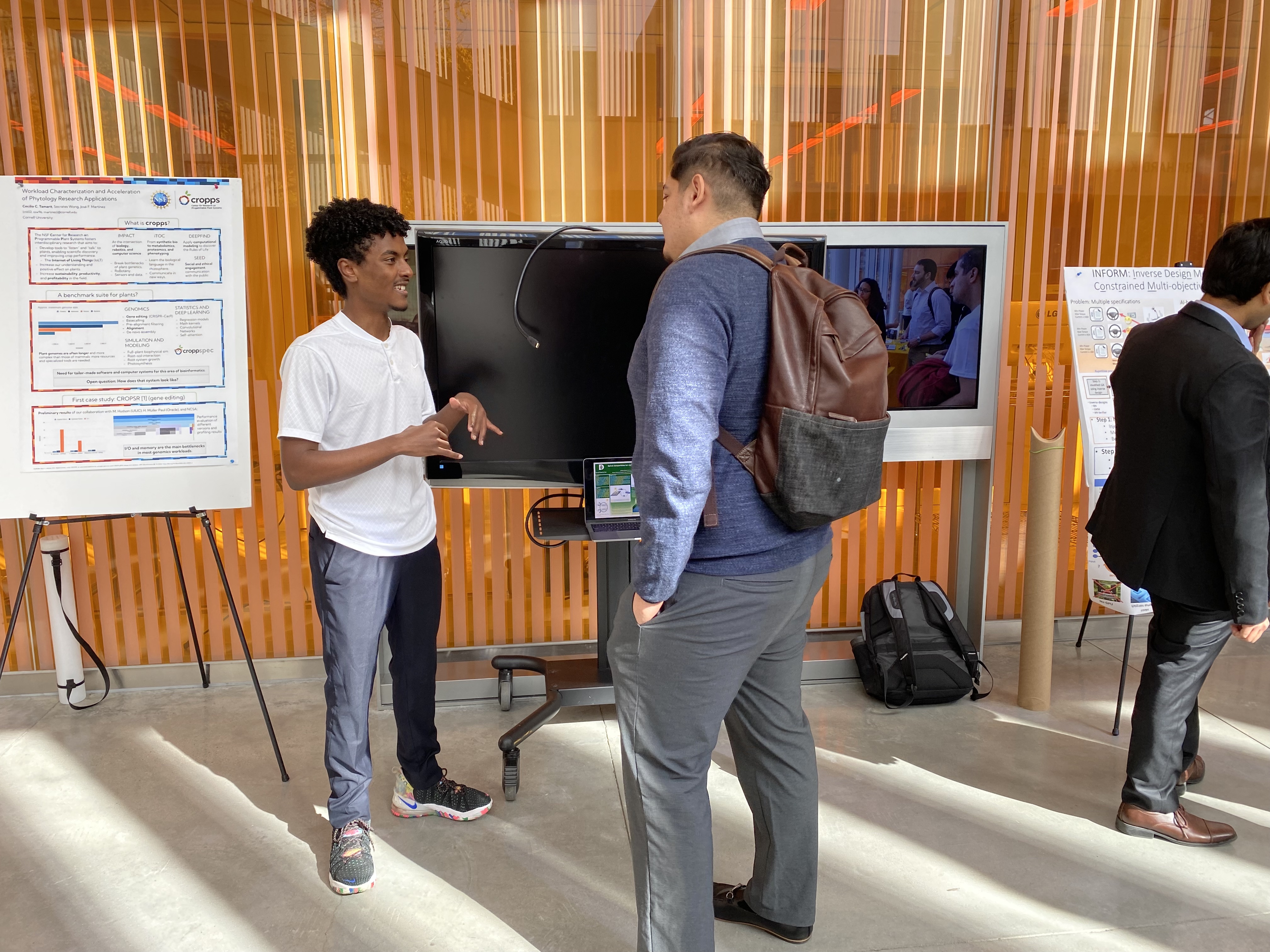 Two students engaged in conversation in front of data. 