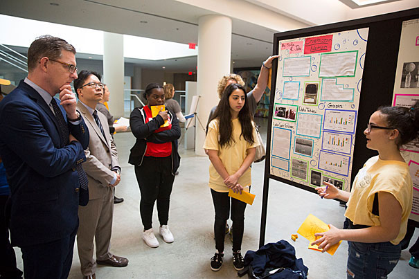 Paul Andrew (from left), vice president for Harvard Public Affairs and Communications, and Kenneth Salim, superintendent of Cambridge schools, listen with Iyla Orock of Rindge Avenue Upper School to Sofia Echandy and Julia Reyes of Amigos School. (Kris Snibbe/Harvard Staff Photographer)