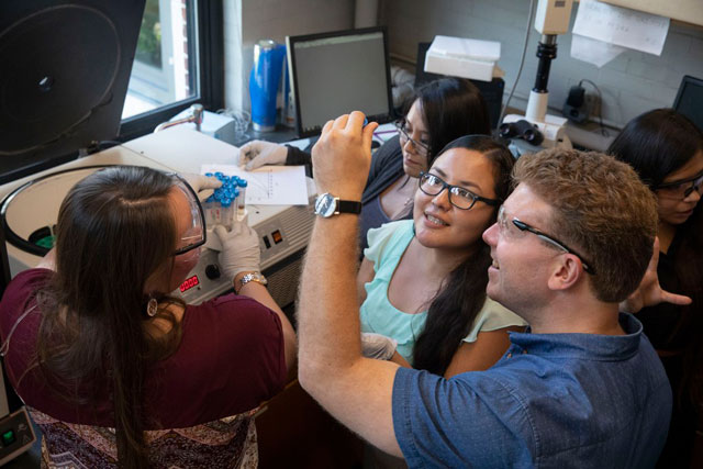 Michael Fink (right) holds up a test tube following a spin in the centrifuge. Kris Snibbe/Harvard Staff Photographer