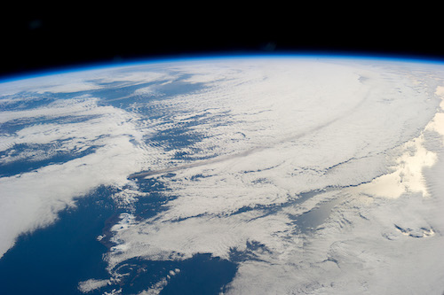 A trail of smoke can be seen from the 2013 eruption of the Pavlof volcano, which spewed an ash cloud 20,000 feet into the atmosphere that traveled southeastward over the North Pacific Ocean. The volcanos that may have contributed to snowball Earth spanned almost 2000 miles and erupted continuously for years. (Image courtesy of NASA)