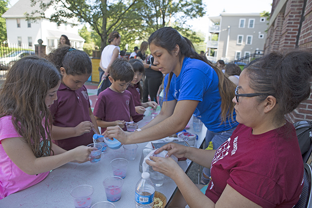 REU students Dominique Pablito (left) and Trisheena Kills Pretty Enemy use different colored sand to explain how hydrophobic materials interact with water. (Photo by Adam Zewe/SEAS Communications)