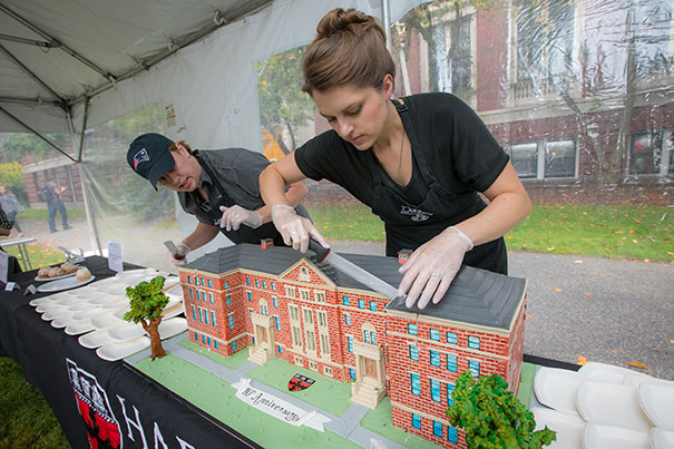 Caterers make the first cut into a birthday cake baked in the shape of Pierce Hall. Eliza Grinnell/SEAS Communications