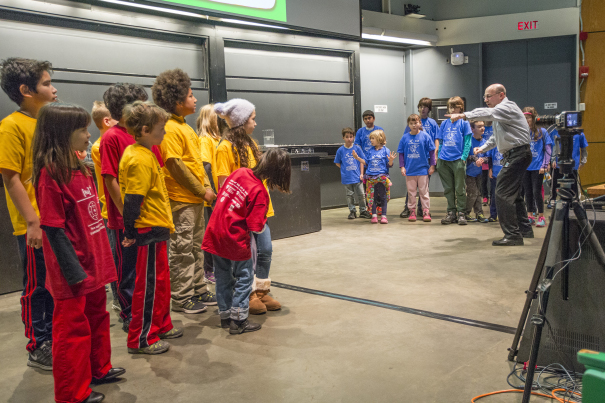 Professor Howard Stone directs children in an interactive demonstration of water dissolving a salt crystal.