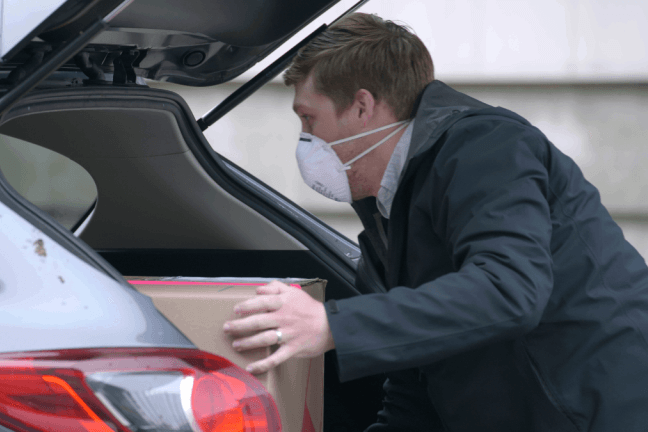 Dan Reynolds taking box out of car trunk