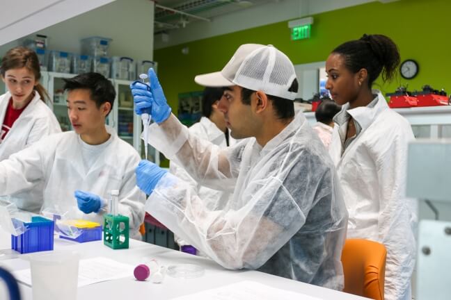 A student practices pipetting at the Science and Engineering Complex