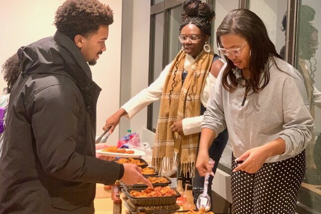 Attendees receive their hot wings at the Spring Kickoff event