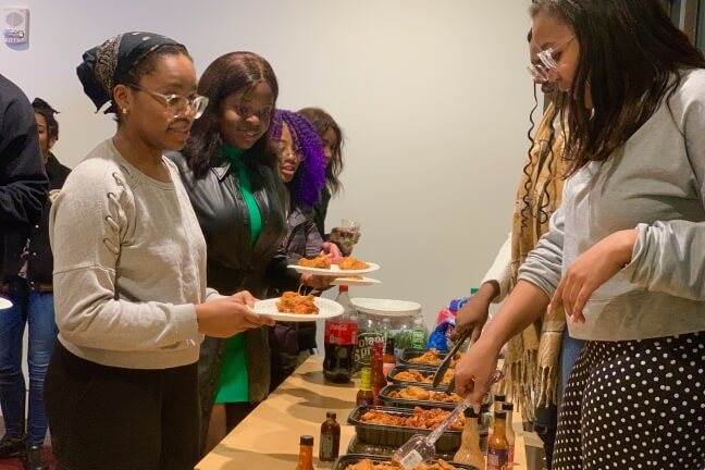 Attendees receive their hot wings at the Spring Kickoff event