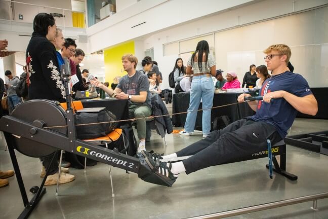 A male Harvard student working out on a mechanical rower