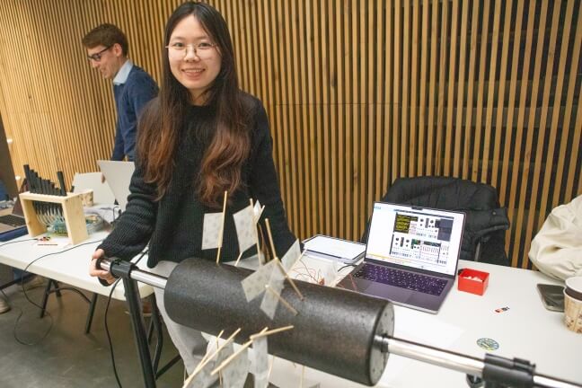 A Harvard student with an instrument made of Polaroid instant photos connected to a rotating drum