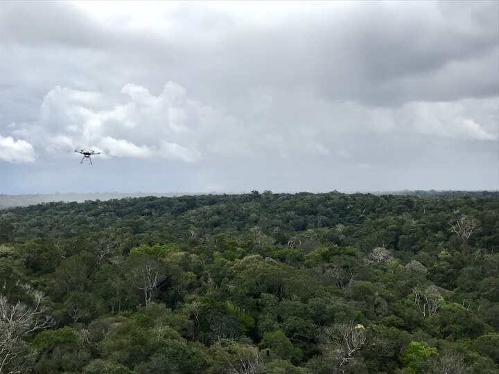 A drone flies towards a rain storm in the Amazon