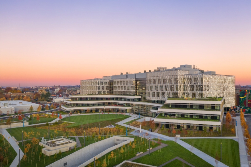 The SEC, pictured in front of a horizon of purple and orange, features a massive green space outside known as the Engineering Yard.