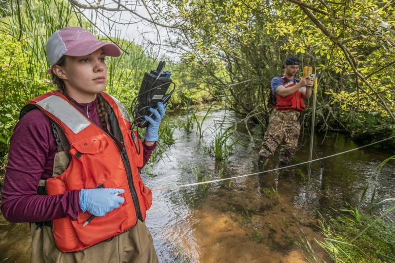 image of researchers standing in the river conducting field work 