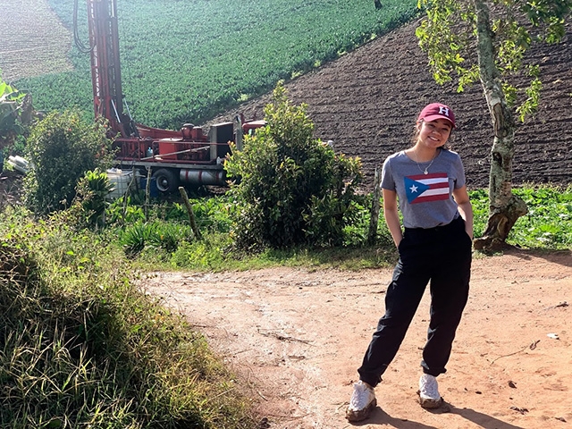 Villafuerte stands near drilling equipment that was used during an Engineers Without Borders trip to Los Sanchez in the Dominican Republic.