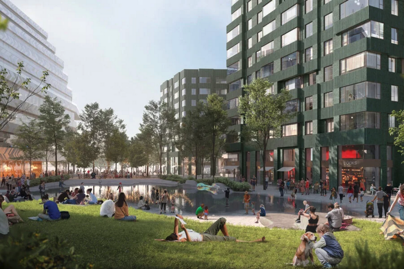 Individuals, families, and pets surround a large water feature/grassy area in the middle of some green and gray buildings.