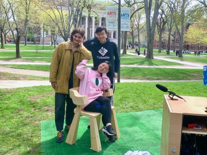 Musical Chairs project lead Peggy Yin, center, demonstrates the bone conduction technique in front of team leads Tamar Sella and Jason Wang in Harvard Yard