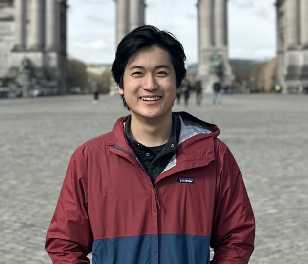 Justin Xu standing in front of columns