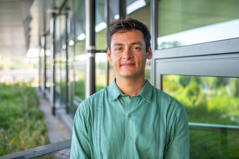 SEAS postdoctoral researcher Francisco Marmolejo-Cossío standing along a balcony railing in the Harvard Science and Engineering Complex