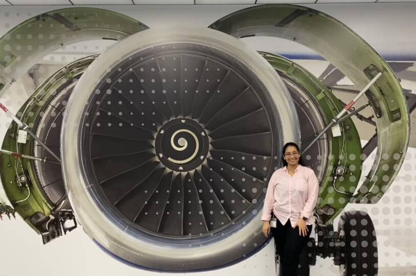 Harvard SEAS student Roaa Marei, S.B. '25, next to a jet engine