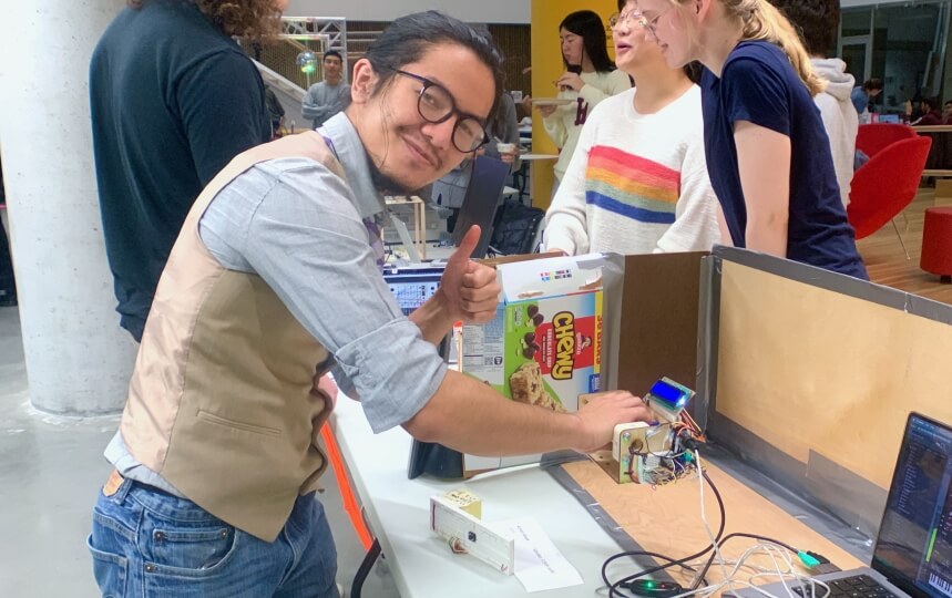 A male Harvard student holding a handheld theremin