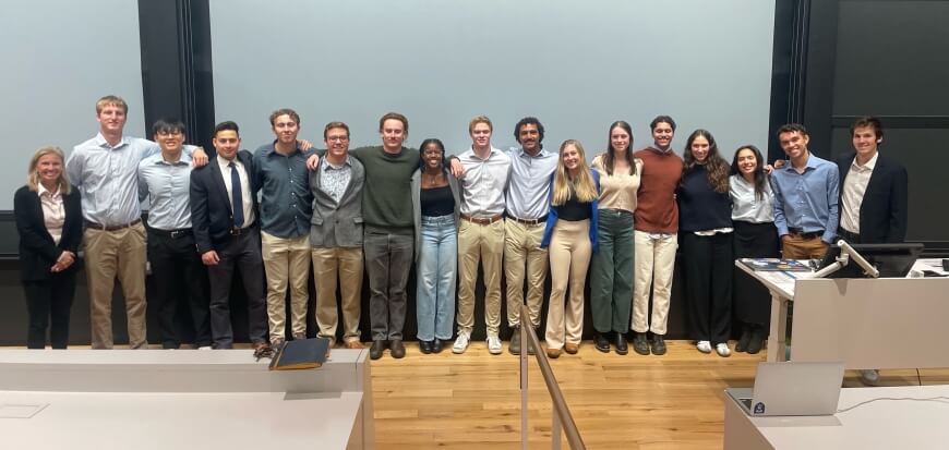 A group of students standing in front of a blank projection screen