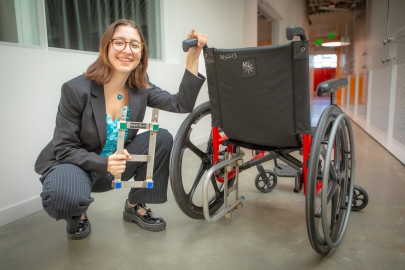 Harvard SEAS senior Zeynep Bromberg kneeling next to a manual wheelchair