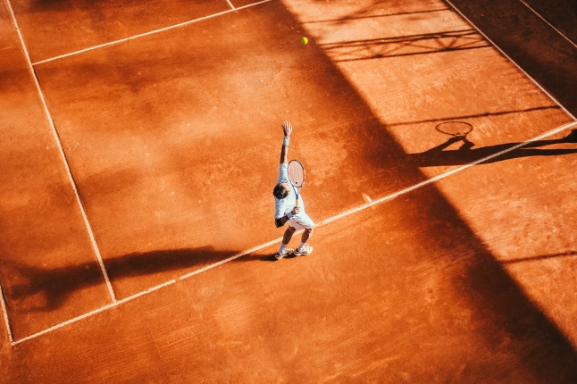 man serving tennis ball