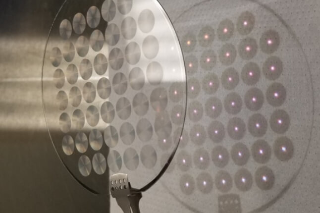 A picture of a group of metalense on a piece of glass with light streaming through